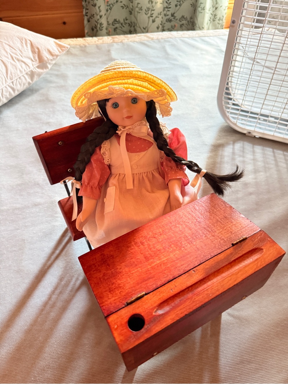 Porcelain Doll in Yellow Straw Hat and Pink Dress with wooden desk
